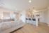 Chic apartment interior with open-plan kitchen and cozy living space, featuring sleek countertops and modern decor.