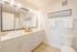 Bright and modern bathroom featuring a large mirror, sleek double sinks, and stylish fixtures.