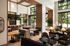 Bright, airy communal space with modern furnishings, large windows, and lush greenery for a welcoming atmosphere.