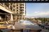 Luxurious modern apartment complex with stunning outdoor pool area and sun loungers, perfect for relaxation.