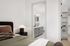 Elegant bedroom suite with cozy bed, stylish nightstand, and a modern en-suite bathroom leading to a chic walk-in closet.