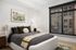 Elegant bedroom with cozy decor, featuring a plush bed, modern artwork, and large windows for natural light.
