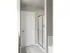 Stand up shower lined with chrome, light grey flooring, white door and light grey painting