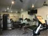 Gym with one wall all mirror, two treadmills, a weight rack, TV in the corner with two ceiling fans. Carpeted area