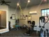 Other view of the gym, with a few work out machines, yoga ball, and an AC box on the wall next to a window