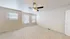 Bright and airy bedroom with plush carpeting, ceiling fan, and large windows offering abundant natural light.