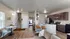 Contemporary open-plan living space featuring a cozy living area, modern kitchen with granite countertops, and stylish dining nook, enhanced by sleek lighting and warm wood floors.