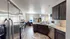 Modern open-concept kitchen and living area with sleek stainless steel appliances, elegant granite countertops, and cozy seating area perfect for relaxation.