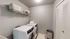 Chic and modern laundry room with sleek washer and dryer, stylish storage solutions, and contemporary design.