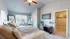 Bright and spacious modern bedroom with stylish decor, featuring large windows, plush bedding, and a walk-in closet.