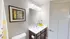 Bright and elegant bathroom featuring modern fixtures, dark wood cabinetry, and tasteful floral artwork.