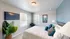 Bright and cozy bedroom with a modern TV, stylish decor, and abundant natural light.