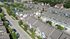 Charming aerial view of a peaceful neighborhood with elegant townhouses and a sparkling pond with a fountain.