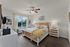 Bright and spacious primary bedroom with large window and modern ceiling fan.