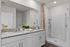Bright and spacious bathroom with dual-sink vanity and walk-in shower.