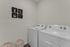 Spacious laundry room with full-size washer and dryer.