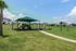 Shaded playground nestled in wide-open green space.