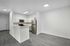 interior pic of deluxe unit kitchen with gray planking and white walls, stainless steel appliances, white cabinets and tile backsplash