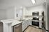 interior pic of deluxe kitchen unit with gray planking and white walls, stainless steel appliances and backsplash
