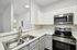 interior pic of deluxe kitchen unit with gray planking and white walls, stainless steel appliances and backsplash