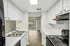 Galley-style kitchen with bright finishes and balcony view.