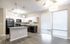 Modern kitchen with sleek granite countertops, contemporary lighting, and abundant natural light from large windows.