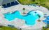 Resort-style pool with splash pad and shaded seating.