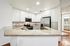 Modern kitchen with sleek granite countertops, white cabinetry, stainless steel appliances, and stylish tile backsplash.