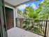 Screened apartment balcony with lush palm views, offering a tranquil outdoor space to relax and unwind.