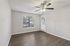 Bright room with elegant wood flooring, large window, and modern ceiling fan, perfect for comfortable living.