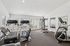 Bright and inviting gym with modern cardio and strength training equipment, featuring large windows for natural light.
