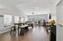 Bright and modern community room with sleek furniture, large windows, and stylish wood flooring, perfect for gatherings and relaxation.