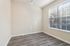 Bright room with sleek hardwood floors and large window offering ample natural light.