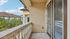Charming balcony with elegant railing offering a scenic view and abundant natural light, ideal for relaxation.