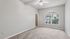 Bright and airy bedroom with plush carpet, large window showcasing scenic views, and a convenient walk-in closet.