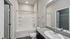 Modern bathroom featuring a sleek granite countertop, spacious bathtub, and elegant fixtures, perfect for relaxation.