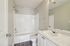 Bright and modern bathroom featuring a sleek vanity, pristine bathtub, and stylish fixtures, perfect for a rejuvenating space.