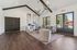 Modern communal lounge with high ceilings, sleek lighting fixtures, and cozy seating overlooking a scenic outdoor pool area.