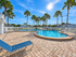 Swimming pool and deck at Willow Lake Crossing with palm trees and updated community buildings.