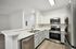 interior pic of deluxe kitchen unit with gray planking and white walls, stainless steel appliances and backsplash