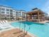 Pool lounge at our senior living community in Flower Mound, TX, featuring beach chairs and a shade structure.
