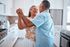 55+ couple dancing in the kitchen