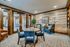 Charming, rustic-style seating area with a wooden accent wall, elegant blue chairs, and cozy ambiance.