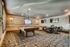 Inviting recreation room featuring a modern billiard table, cozy seating area, and flat-screen TVs, perfect for entertainment and relaxation.