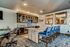 Elegant home bar with plush blue seating, rustic cabinets, and stylish decor for a perfect entertainment space.