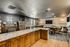 Chic and spacious communal lounge featuring a sleek granite countertop, cozy seating area, and warm wood accents, perfect for entertainment and relaxation.