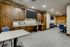 Modern community room with elegant wooden cabinetry, sleek surfaces, and ample seating, ideal for gatherings and entertainment.