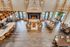 Luxurious open-concept living area with grand stone fireplace, elegant chandeliers, and ample seating for gatherings.