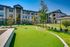 Charming apartment exterior with lush landscaping and a mini-golf green, perfect for outdoor relaxation.
