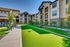 Modern apartment complex with lush green landscape, inviting pathways, and comfortable outdoor seating.